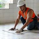 Installatore che posa grandi lastre di ceramica in un cantiere